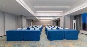 Cette grande chambre comprend des tables bleues et des chaises blanches. dans l'établissement Borrman Hotel Yongzhou Lingling Ancient Town Government, à Yongzhou