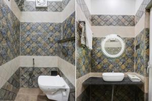 Un baño con inodoro, lavabo y espejo. en Super Townhouse Vishwanath Temple Varanasi, en Varanasi