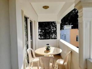 a balcony with a table and chairs and a window at Rayon Bleu A3 two bedroom apartment-perfect sea escape! in Flic-en-Flac