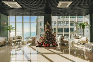 a christmas tree in the middle of a lobby at Hotel Costa Geobukseom in Siheung +24 photos