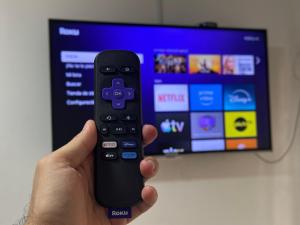 une personne tenant une télécommande devant une télévision dans l'établissement Lofthouse 14, à Cali