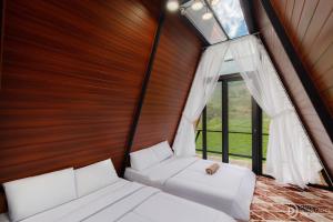 迪昂Dieng Ceria Resort的有窗户的房间里有两张床