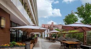 a patio with tables and chairs and umbrellas at Gotel Capital in Beijing