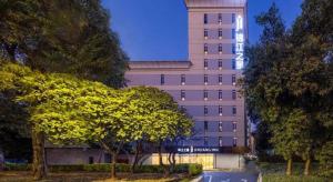a building with a tree in front of it at Jinjiang Inn Shenzhen Airport in SZX