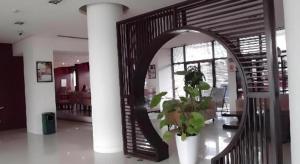 une pièce avec un escalier en colimaçon avec un miroir et une plante dans l'établissement Jinjiang Inn Shaoxing Shengli West Road Luxun Hometown, à Shaoxing