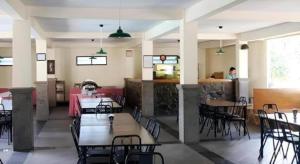 a dining room with tables and chairs in a restaurant at Hotel Augusta Garut in Garut