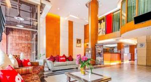 ein Wohnzimmer mit Sofa und Tisch in der Unterkunft OYO 441 Grand Thara Hotel in Surat Thani