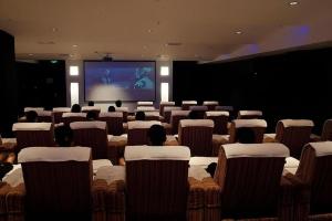 a room full of chairs with a person on a screen at Guangdong Nanmei Osotto Hotel in Guangzhou +285 photos