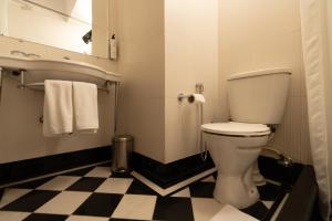 新德里Broadway An Alivaa Collection Hotel的一间带卫生间的浴室以及黑白格子地板。