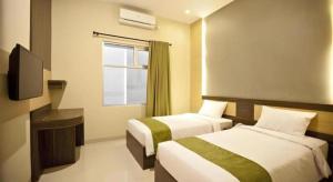 a hotel room with two beds and a television at dPalma Hotel in Bandung +172 photos