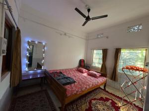 西里古里The Indoor Retreat的一间卧室配有一张床、镜子和吊扇 更多8张照片