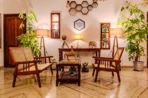 ein Wohnzimmer mit zwei Stühlen und einem Tisch in der Unterkunft Water Element Room By HEXA Stays in Thiruvananthapuram