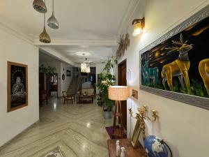 ein Flur mit einem Wohnzimmer, in dem ein Gemälde eines Hirsches hängt in der Unterkunft Water Element Room By HEXA Stays in Thiruvananthapuram