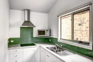 a kitchen with a sink and a microwave at Anchors Port Campbell in Port Campbell