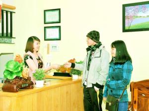 trois femmes se tiennent devant une caisse enregistreuse dans l'établissement Dalat Flower Hotel & Spa, à Đà Lạt