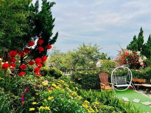 a garden with a white chair and flowers at Mây Hoa Tiên Villa - House in Da Lat +247 photos
