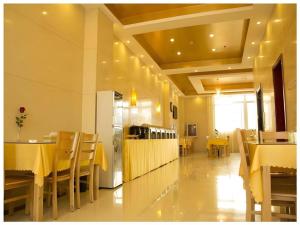 a restaurant with yellow tables and chairs in a room at GreenTree Inn Lianyungang Guanyun Bus Station Zhenxing Garden Express Hotel in Guanyun