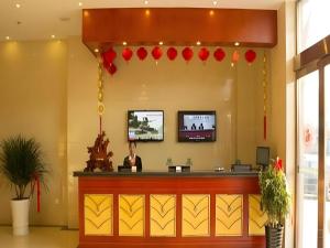 a woman sitting at a counter in a waiting room at GreenTree Inn Lianyungang Guanyun Bus Station Zhenxing Garden Express Hotel in Guanyun