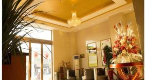 a restaurant with a table with flowers in a room at GreenTree Inn Lianyungang Guanyun Bus Station Zhenxing Garden Express Hotel in Guanyun