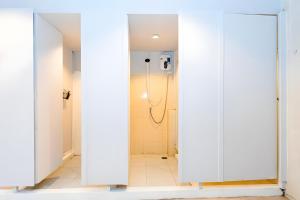 een badkamer met witte deuren en een douche bij XX Mitr Inn Sukhumvit 2 - มิตร อินน์ สุขุมวิท 2 in Bang Kapi +50 foto's