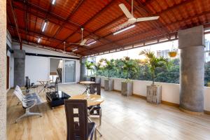 un bureau avec des tables, des chaises et des palmiers dans l'établissement Sunrise A Boutique Hotel, Kondapur - Gachibowli, à Kondapur