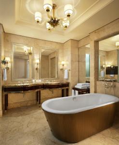 a bathroom with a large tub and a large mirror at The St Regis Singapore in Singapore