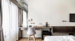 ein Schlafzimmer mit einem Schreibtisch, einem Bett und einem Stuhl in der Unterkunft XOTEL in Ban Non Muang
