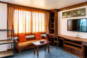 un salon avec un canapé et une télévision dans l'établissement Hua Hin Loft, à Hua Hin