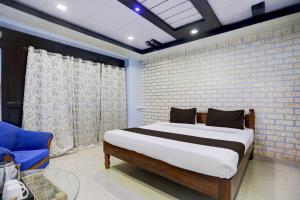 Un dormitorio con una cama y una silla azul. en Super Hotel O Hanuman Nagar Kankarbagh Formerly Home Town, en Bankipur 22 fotos más