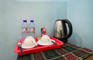 贡布Nary Garden的一个红色托盘，上面放着两个杯子和两瓶水。