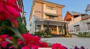 a house with pink flowers in front of it at Chiangkhan Town Hotel in Chiang Khan