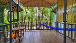 a hammock on a screened in porch with trees at Nary Garden in Kampot