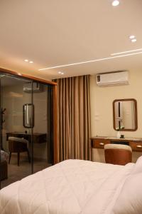 Una habitación de hotel con una cama, un escritorio y un espejo. en Cozy Luxe Apartment in Central Aswan, en Aswān