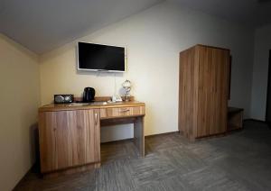 una stanza con una scrivania con una televisione sul muro di Uzdrowisko Połczyn Zdrój - Sanatorium Irena a Połczyn-Zdrój