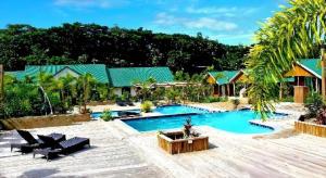 un complejo con piscina y palmeras en Orator Hotel, en Siusega