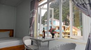 - une chambre avec une table, deux chaises et une fenêtre dans l'établissement Rose Hotel, à Cừ Lạc