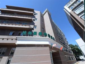 BaitalingにあるGreenTree Inn Hebei Qinhuangdao Olympic Center Express Hotelの緑の植物が植えられた建物