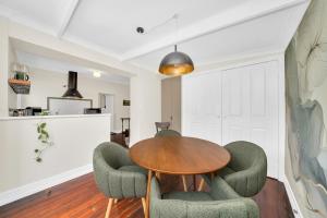 a dining room with a wooden table and green chairs at Bassett Cottage- Heritage Listed- with 3 bedrooms- close to train and shops  +19 photos