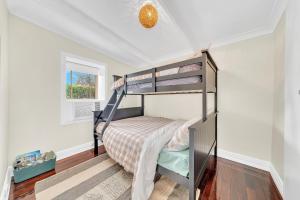a bedroom with two bunk beds in a room at Bassett Cottage- Heritage Listed- with 3 bedrooms- close to train and shops 