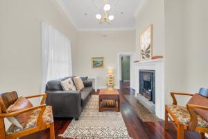 a living room with a couch and a fireplace at Bassett Cottage in Gawler South with 3 bedrooms and close to city train and shops 