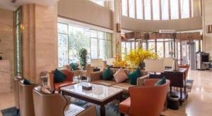 un salon avec un canapé, une table et des chaises dans l'établissement Jinjiang Metropolo Hotel - Turpan Administration Center, à Turfan