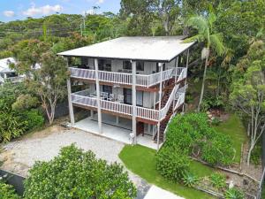 Hibiscus Haven 1BR getaway in Valla Beach في Valla Beach: اطلاله هوائيه على بيت ابيض مع شرفه