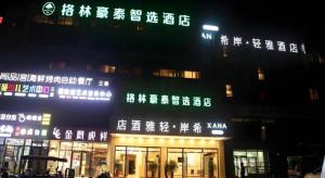 un bâtiment avec des écritures chinoises dessus la nuit dans l'établissement GreenTree Inn Beijing Shunyi Fengbo Metro Station, à Qianfengbo