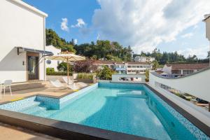 a swimming pool in the backyard of a house at Jiuhua Goodstay Inn in Chizhou