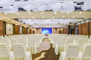 a banquet hall with white chairs and a stage at Yitel Tai'an Taishan Hongmen Daimiao in Tai'an