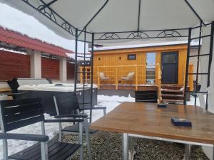 una casa con una mesa y sillas en un patio en Villa Rustica, en Bešeňová