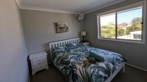 a bedroom with a bed and a window at Flamingo Sunset Retreat in Old Bribie +9 photos