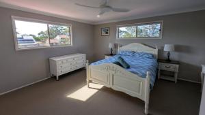 a bedroom with a white bed and two windows at Flamingo Sunset Retreat in Banksia Beach +12 photos