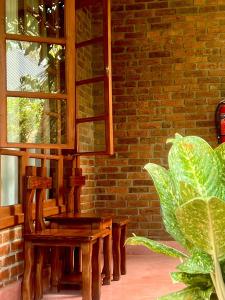 un banco de madera sentado frente a una pared de ladrillo en Sunset Retreat Hotel, en Arusha