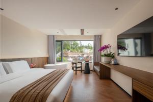 a hotel room with a large bed and a window at Jiuhua Goodstay Inn in Chizhou +88 photos